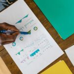 Illustration of a person planning a crowdfunding campaign goal with a checklist, calculator, and budget chart on a desk