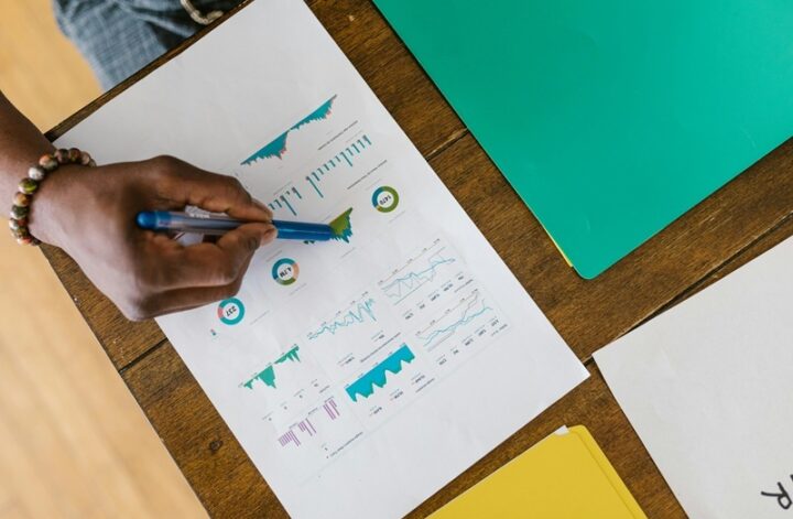 Illustration of a person planning a crowdfunding campaign goal with a checklist, calculator, and budget chart on a desk