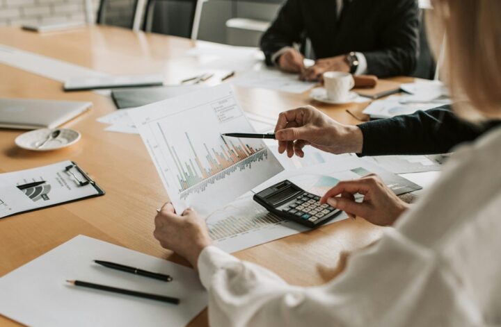Business professionals reviewing financial charts and graphs during a meeting to plan budgets and allocate resources.