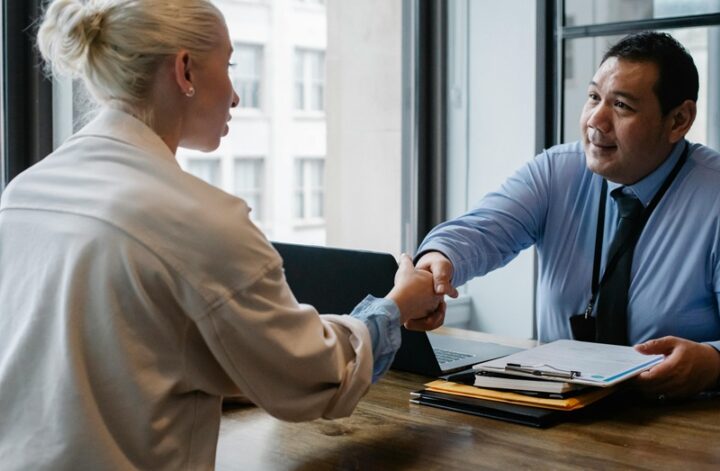 Business professionals shaking hands during a meeting, symbolizing partnership and successful collaboration.